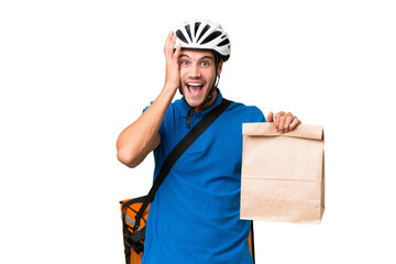 Young caucasian man taking a bag of takeaway food over isolated background with surprise and shocked facial expression