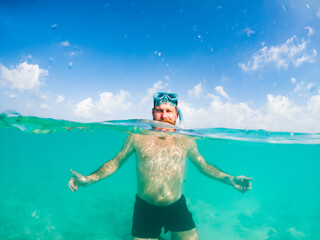 man snorkeling in crystal clear tropical sea