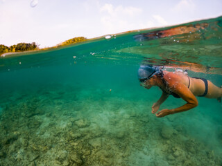 woman snorkeling in clear tropical sea