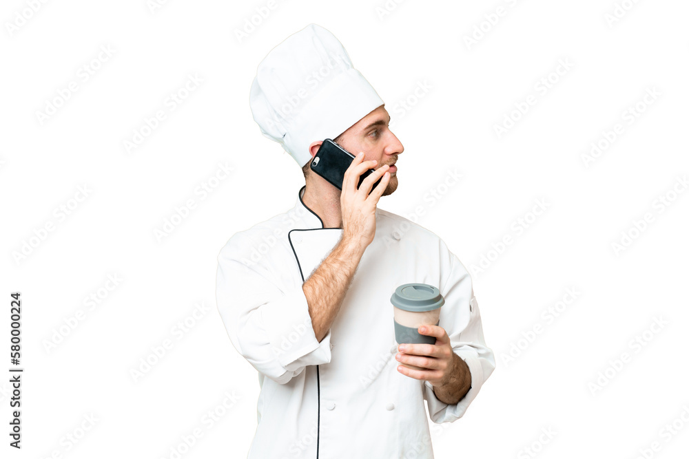 Sticker Young blonde man Chef over isolated chroma key background holding coffee to take away and a mobile