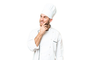 Young blonde man Chef over isolated chroma key background thinking an idea while looking up