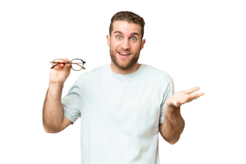 Young handsome blonde man with glasses over isolated chroma key background with shocked facial expression