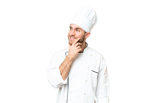 Young blonde man Chef over isolated chroma key background thinking an idea while looking up