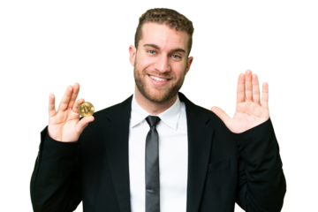 Young business blonde man holding a Bitcoin over isolated chroma key background saluting with hand with happy expression
