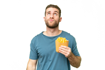 Young handsome blonde man holding fried chips over isolated chroma key background and looking up