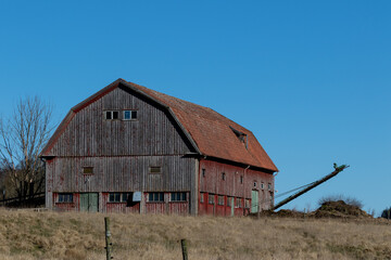 Rustic red barn and manure conveyor belt in rural setting