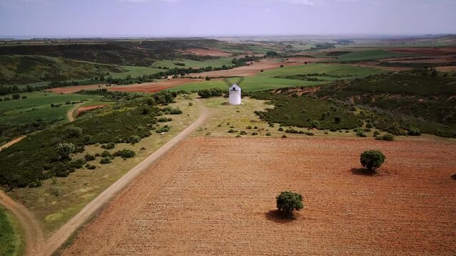 Windmill on the hill at sunset in Castilla la Mancha, Spain. View from the air, bird flight.