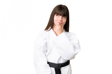 Little Caucasian girl doing karate over isolated background having doubts and with confuse face expression