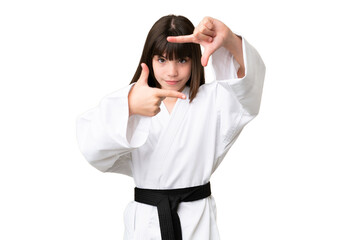 Little Caucasian girl doing karate over isolated background focusing face. Framing symbol © luismolinero