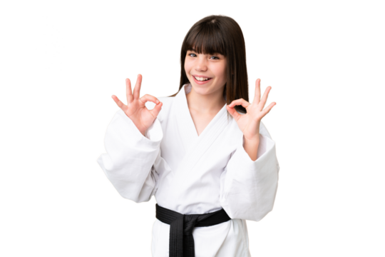 Little Caucasian girl doing karate over isolated background showing an ok sign with fingers