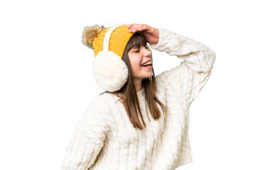 Little caucasian girl wearing winter muffs over isolated background has realized something and...