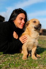 a beautiful dark-haired girl, in a black sweater spends time with a dog, a homeless dog,friends lie...