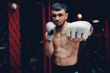 Portrait man MMA fighter on octagon ring. Fighting Championship, dark background
