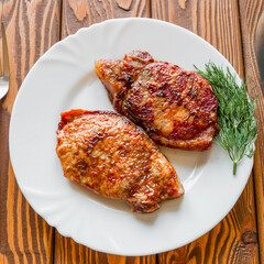 grilled meat with dill on a white plate