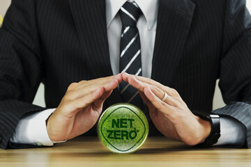 Businessman hand above the word NET ZERO concept. Net zero emissions by 2050. Green renewable...