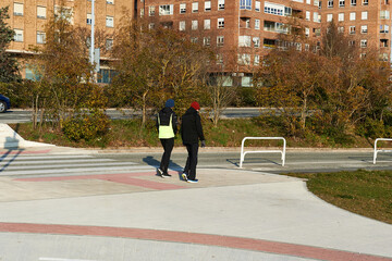 two men walk in sportswear next to a zebra crossing