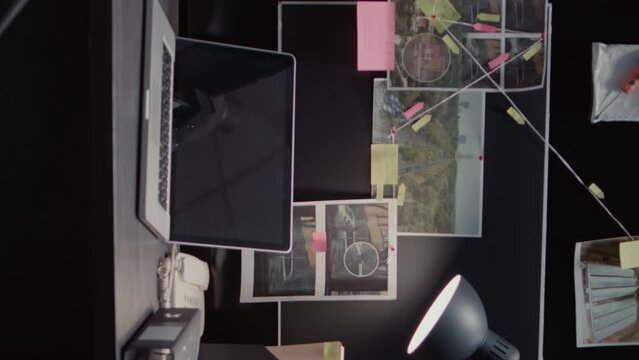 Vertical video: Evidence board with case files or investigation clues on police archive wall map, surveillance phots and witness statements. Empty law enforcement office filled with criminal records.