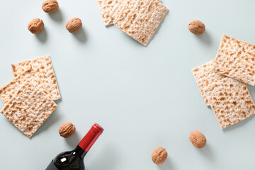 Fototapeta na wymiar Matzah, red kosher and walnut traditional ritual Jewish bread in plate on blue background with copy space. Pesach Jewish holiday. Passover food and celebration concept. View from above.