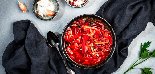 Summer Vegetable Soup with  cabbage, beets, and herbs. Russian borscht in plate on grey kitchen...