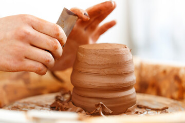 Cropped close up image. Woman's hands molding clay, making a clay pottery in the handicraft...