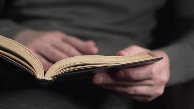 a young man reads a book and makes an entry in a journal. studies. close-up.