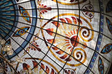 Fototapeta na wymiar magnificent detail of a Gothic-style stained glass ceiling. Beautiful geometric shapes, vibrant colors, and sunlight create a stunning play of light and shadow.