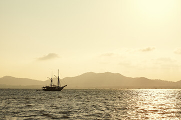 Sunset seascape. Ship sailing the sea.