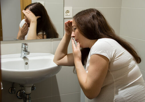 A Pregnant Woman Struggling With Morning Sickness At The Bathroom Holding Her Head