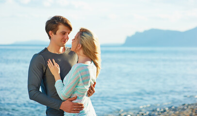Love and romance. Honeymoon on the sea shore. Beautiful loving couple embracing on the beach