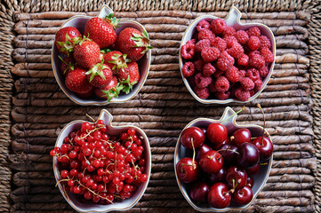 Strawberries, cherries on the rustic surface.