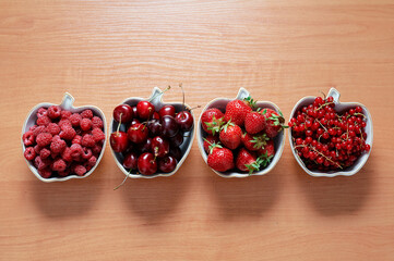 Strawberries, cherries, currant on the wooden surface.