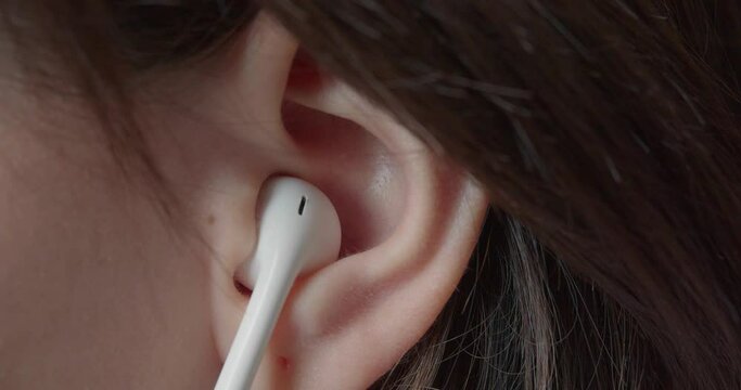 Ear of a teenage girl - she puts in a small earpiece to listen to music.