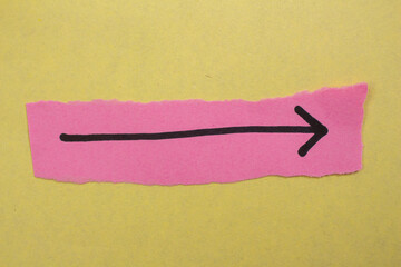 Black arrow sign on a pink paper