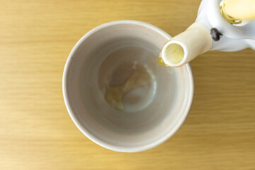 急須で湯呑みに緑茶を入れるイメージ