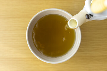 急須で湯呑みに緑茶を入れるイメージ