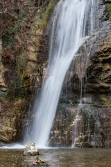 Landscape photo. Waterfall in early spring forest. Nature of Georgia. Vertical close up photo
