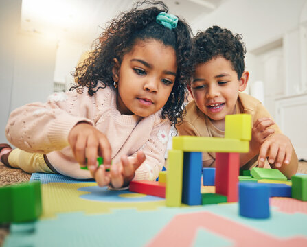Building blocks, happy children and floor with toys for playing, bonding and educational games at home. Family, child development and boy and girl enjoy creative activity, learning and relaxing