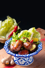 Food concept Sai krok Isan or Isaan Thai-Laos fermented pork and rice sausages in Tradition thai ceramic pedestal plate on black background with copy space - obrazy, fototapety, plakaty