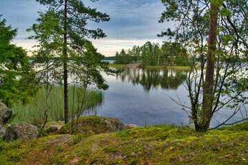 Island with pine forest in beautiful fresh blue lake, Park Mon Repos, Vyborg, Russia
