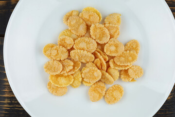 Several cornflakes on a white plate