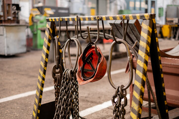Metal slings hang on hooks in the production hall at a metallurgical plant. Metal cables and chains...