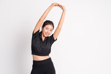 Fototapeta na wymiar woman wearing black sportswear stretching hands raised on background isolated