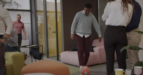 African male juggling a ball while in the office - Powered by Adobe