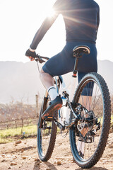 Fototapeta na wymiar Back of man, bicycle and cycling in nature, countryside and training for triathlon, sports and flare. Cyclist, mountain bike and off road path for fitness, exercise and waiting on a break in sunshine
