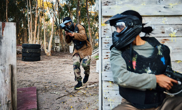 Paintball, sports and man with gun for battle, game or competition outdoors on field. War fight, military army and male soldier with weapon on shooting range while hiding from opponent for exercise.