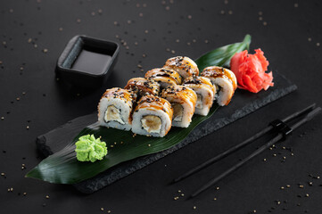 Sushi roll with eel, sesame and Philadelphia cheese on a black background. Sushi menu. Japanese...