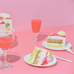 Holiday table with red wine champagne two glasses and cake. Pink background
