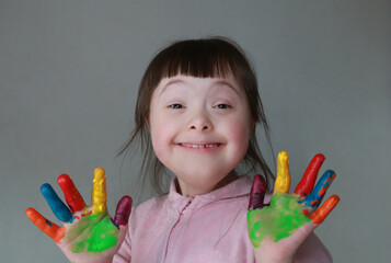 Cute little kid with painted hands. Isolated on grey background.