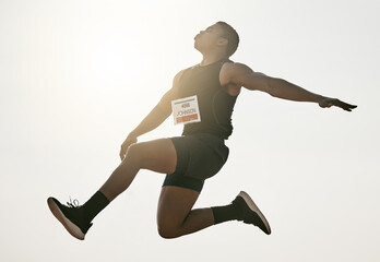 Thats one hell of a jump. Low angle shot of a handsome young man leaping high into the air during...