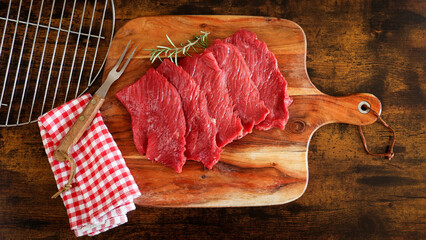  plusieurs steaks de bœuf crus, en gros plan, sur une planche à découper